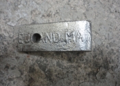 A makers stamp located on one of the wrought iron hangers. "Edmand Maa" is all that we can see...